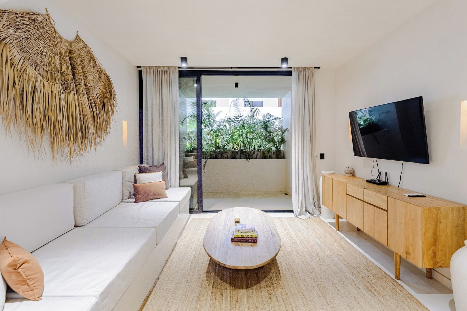 A modern living room with a sofa, a coffee table, a TV, and a wooden cabinet.