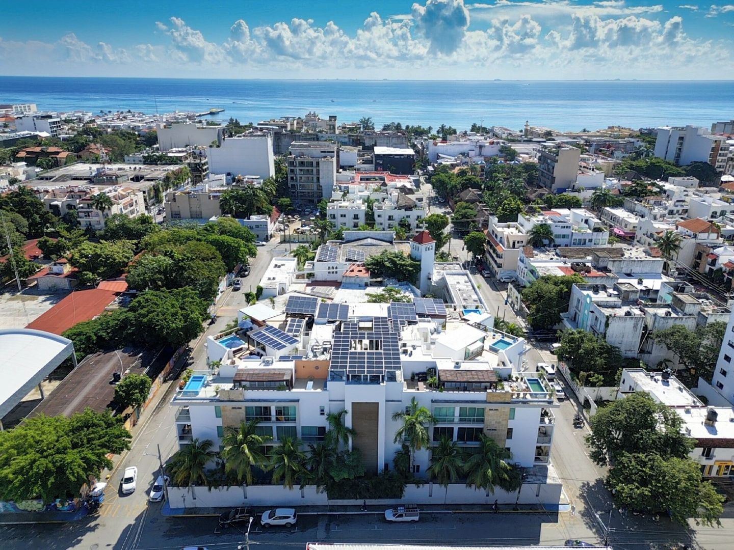 Paisagem costeira urbana com edifícios, ruas e vista clara do oceano.