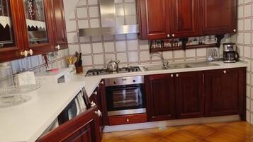 A kitchen with wooden cabinets, a stove, and a tiled backsplash.