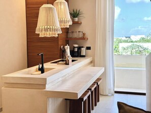 A modern kitchen with a central island, pendant lights, and a view of the outdoors. - Please note: electricity is not included in reservations longer than 28... (Tulum)