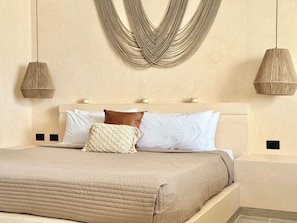 A bed with a beige quilt, white and brown pillows, and a woven headboard. - Please note: electricity is not included in reservations longer than 28... (Tulum)