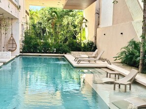A swimming pool with lounge chairs and a stone wall. - Please note: electricity is not included in reservations longer than 28... (Tulum)