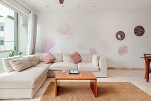 A modern living room with a sectional sofa, a coffee table, and decorative wall art. - Penthouse 3BR · Jacuzzi · 6 min a la playa (Playa del Carmen)
