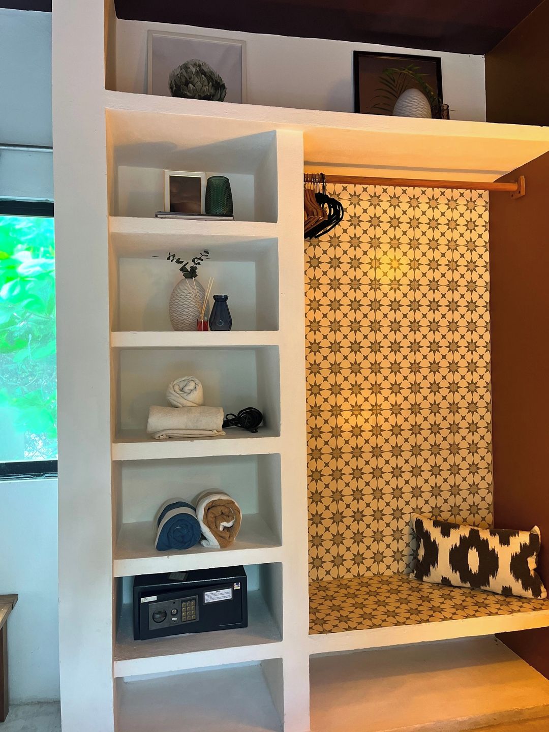 A white shelving unit with various items including a radio, folded towels, and decorative objects.