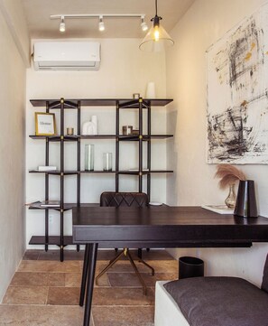 A room with a dark wooden desk, a chair, a bookshelf, and a wall-mounted air conditioner. - NUEVO Apartamento en La Veleta (Tulum)