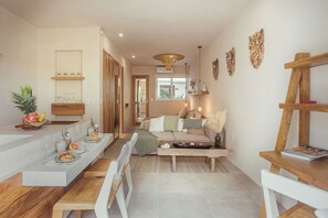 A modern kitchen with a dining area, a sofa, and a coffee table. - NUEVO Apartamento en La Veleta (Tulum)