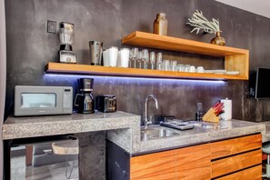 A modern kitchen with a built-in microwave, coffee maker, and a stainless steel sink. - Embrace the ultimate Tulum experience in our exclusive loft, perfectly... (Tulum)
