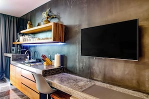 A modern kitchen with a built-in TV, wooden shelves, and a marble countertop. - Embrace the ultimate Tulum experience in our exclusive loft, perfectly... (Tulum)