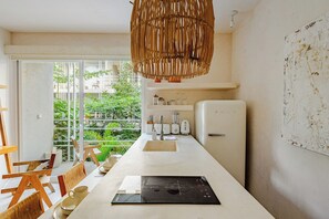 A modern kitchen with a large island, white appliances, and a view of greenery outside. - Please note: electricity is not included in reservations longer than 28... (Tulum)