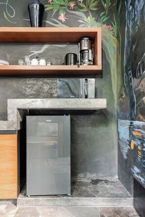 A kitchen with a built-in refrigerator, a coffee maker, and a shelf with kitchenware. - Centrally located loft in Tulum · pools and hot tubs (Tulum)