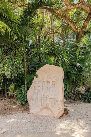 A large stone with carvings in a garden setting. - Centrally located loft in Tulum · pools and hot tubs (Tulum)