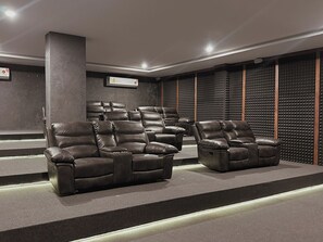 A home theater room with leather reclining chairs and a soundproof wall. - Private terrace with jungle views (Tulum)