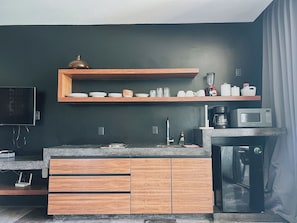 A modern kitchen with wooden cabinets, a built-in microwave, and a coffee maker. - Please note: electricity is not included in reservations longer than 28... (Tulum)