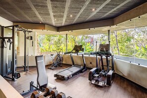 Ein Fitnessstudio mit Cardio-Geräten, Krafttrainingsmaschinen und Laufbändern.