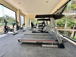 Ein Fitnessstudio mit Cardiogeräten, Krafttrainingsmaschinen und Laufbändern.