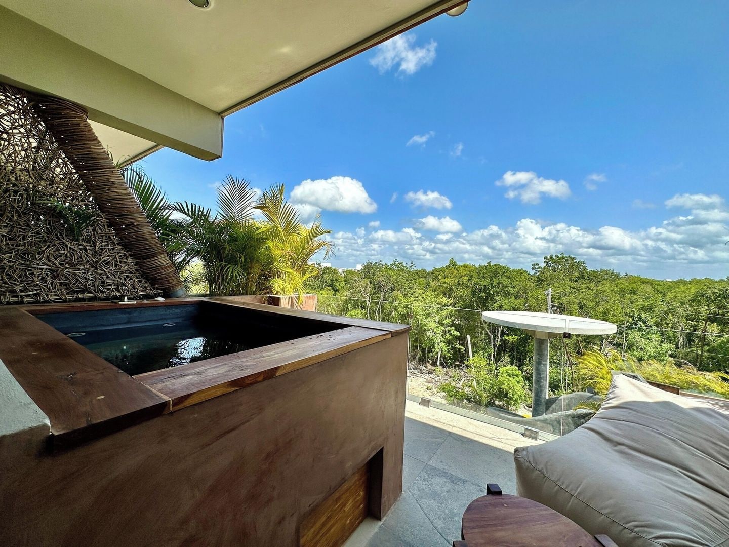 A modern outdoor hot tub area with a view of a lush forest.