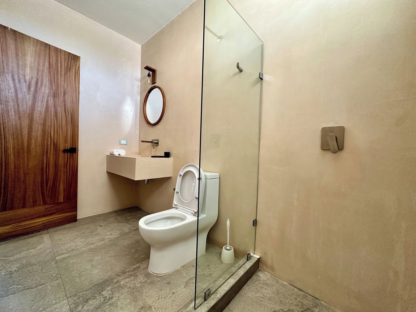 Un baño con inodoro, lavamanos y espejo.