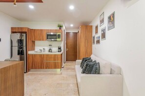 A modern kitchen with a built-in microwave, refrigerator, and a wooden cabinet. - Caminando a la 5a Ave y la playa (Playa del Carmen)
