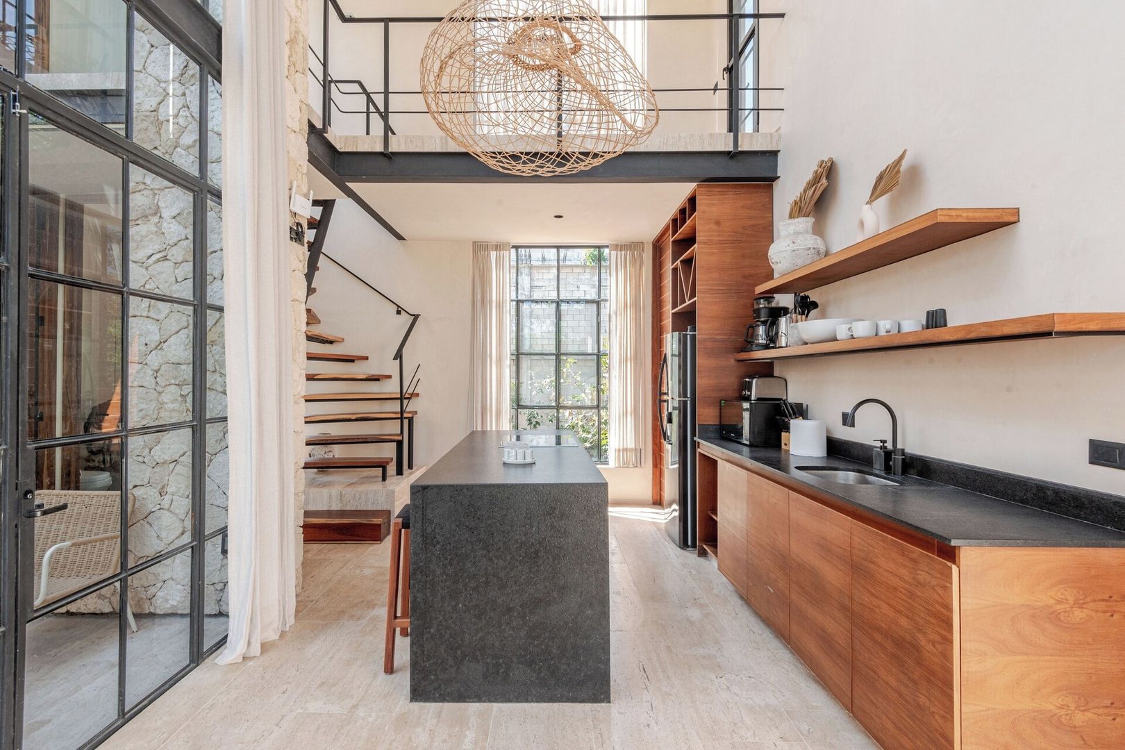 Een moderne keuken met een centraal eiland, houten kastjes en een hanglamp.