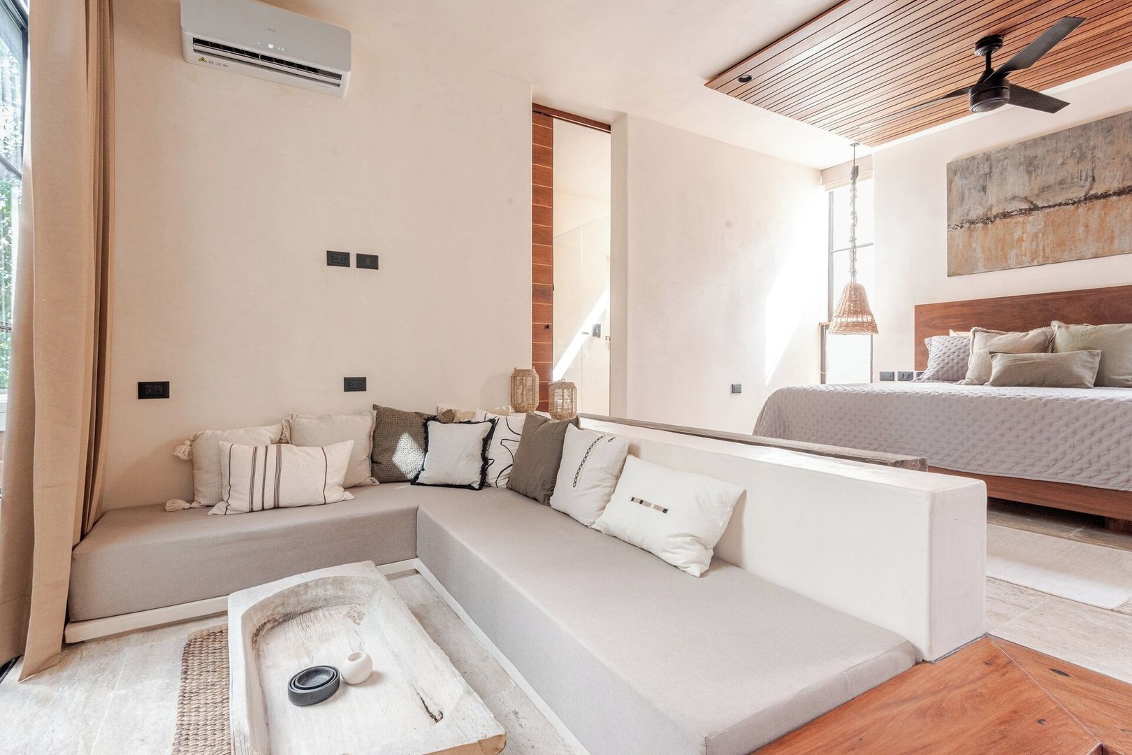 Una camera da letto moderna con un letto grande, un divano e una ventola a soffitto.