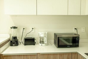 A kitchen counter with a blender, toaster, coffee maker, and microwave. - Please note: electricity is not included in reservations longer than 28... (Tulum)
