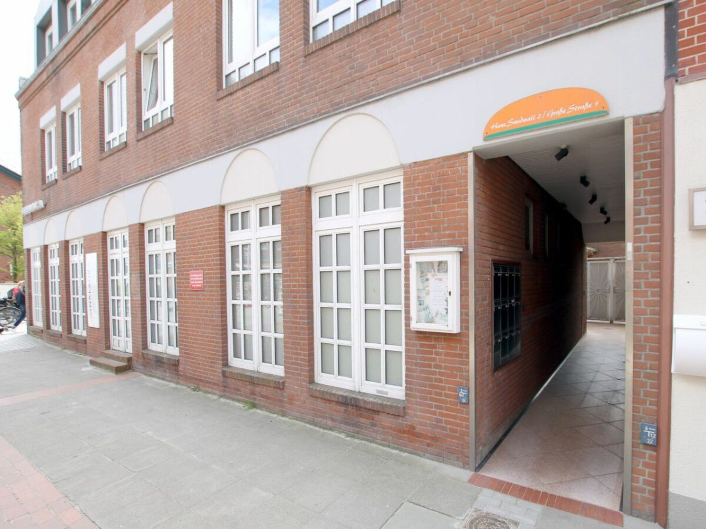A red brick building with white-framed windows and a covered entrance.