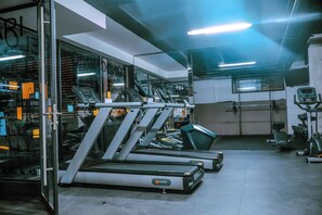 Ein Fitnessstudio mit Laufbändern, Kraftgeräten und Trainingsausrüstung.