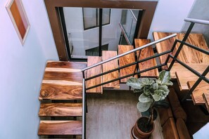 Eine Holztreppe mit Metallgeländern und einem Blumentopf am Fuß.
