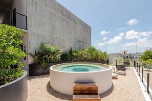 A rooftop terrace with a circular hot tub, surrounded by potted plants and a seating area. - Premium studio · Private immersion · Gym and Sauna (Tulum)