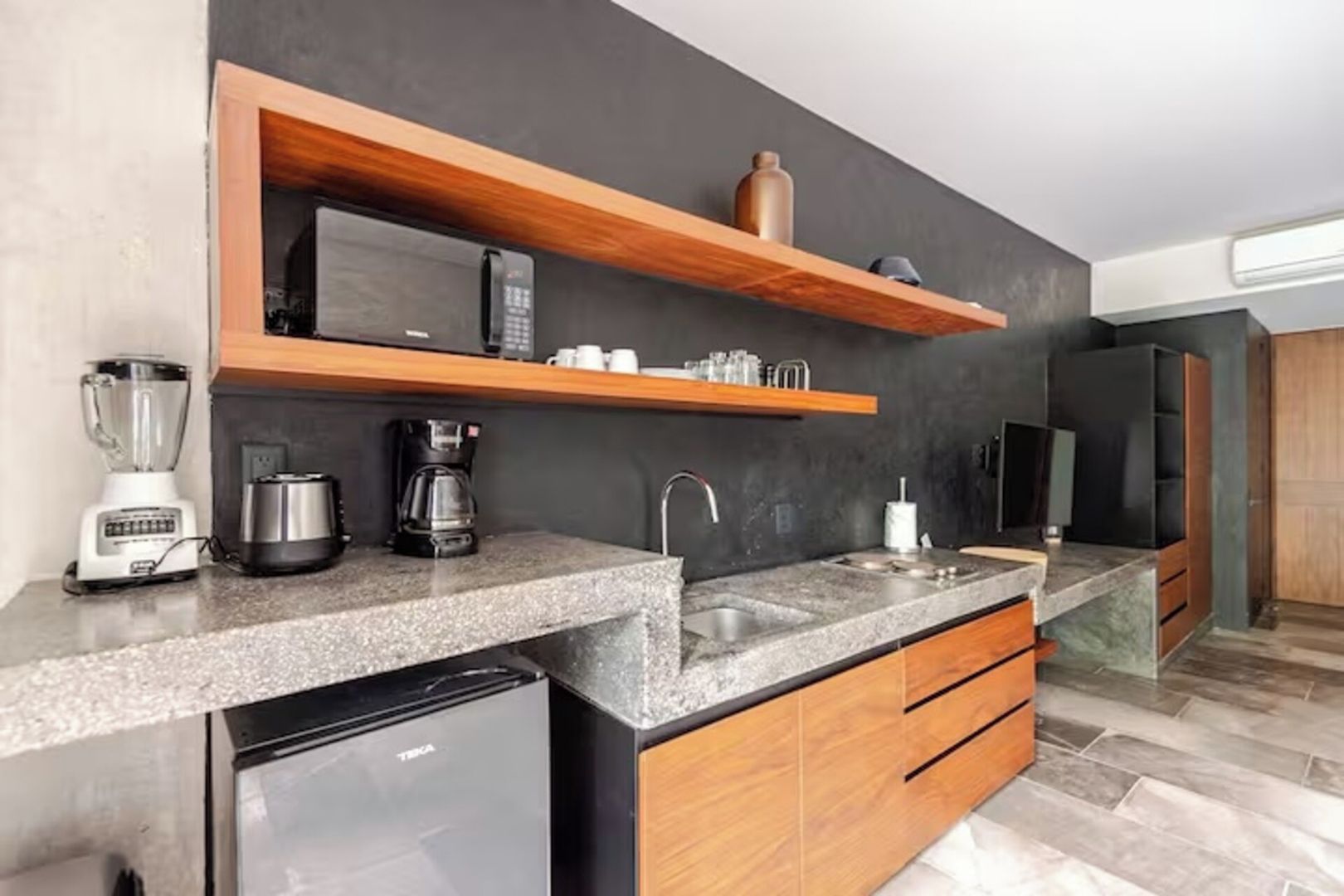 Una cucina moderna con lavastoviglie integrata, macchina del caffè e microonde.