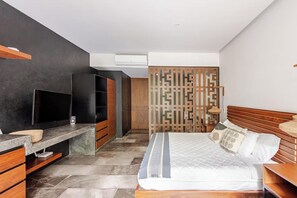 A modern hotel room with a bed, a TV, a desk, and a wardrobe. - Premium studio · Private immersion · Gym and Sauna (Tulum)