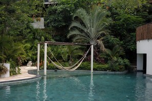 A pool with a hammock and palm tree, surrounded by lush greenery. - 3BR Favorite · Private Pool + Cenote · Tulum (Tulum)