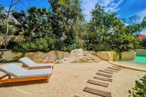 A sandy beach area with lounge chairs and a pool. - Main Street to the beach | Coba Av. (Tulum)