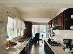 A kitchen with a long countertop, a stove, and cabinets. - Hot Pool with Solar Panels! (Jiutepec)
