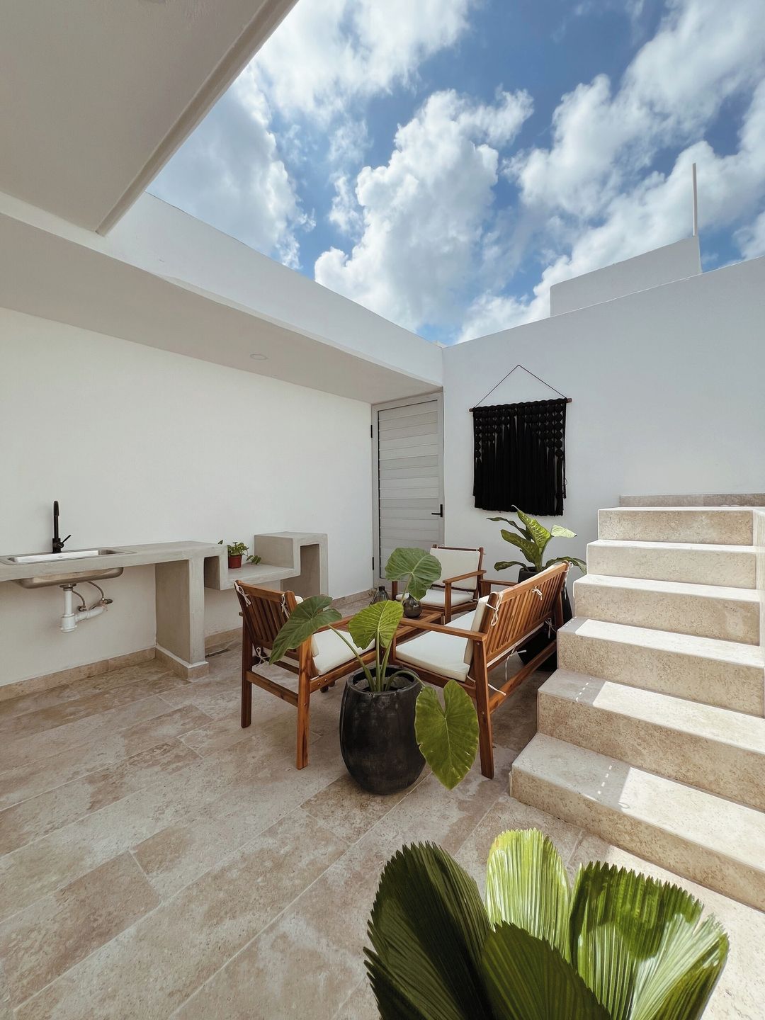 Eine moderne Außenpatio mit Essbereich, einer Treppe und Blick zum Himmel.