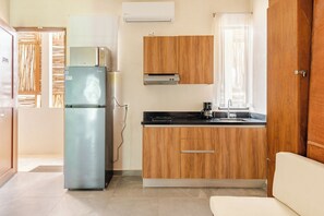 A compact kitchen with a refrigerator, wooden cabinets, a countertop, and a window. - Stylish Tulum Apt w/Jacuzzi and Pools (Tulum)