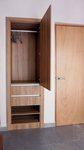 Ein Holzkleiderschrank mit mehreren Einlegeböden und einer Tür.
