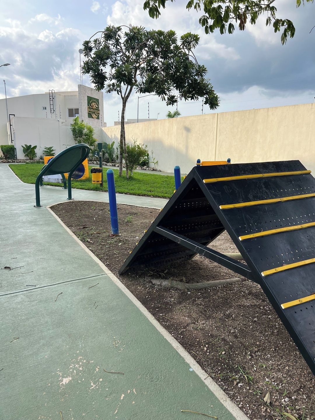 A playground with a climbing structure and a green pathway.