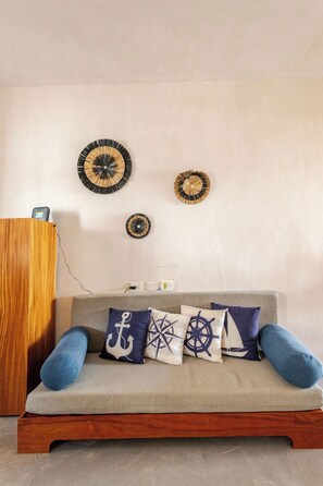 Ein Zimmer mit einer Couch, Wanddekoration und einem Holzkabinett.
