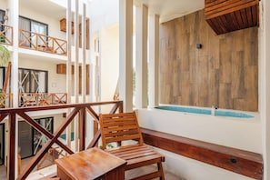 Ein Balkon mit Holzmöbeln, einem Pool und einer Holzwand.