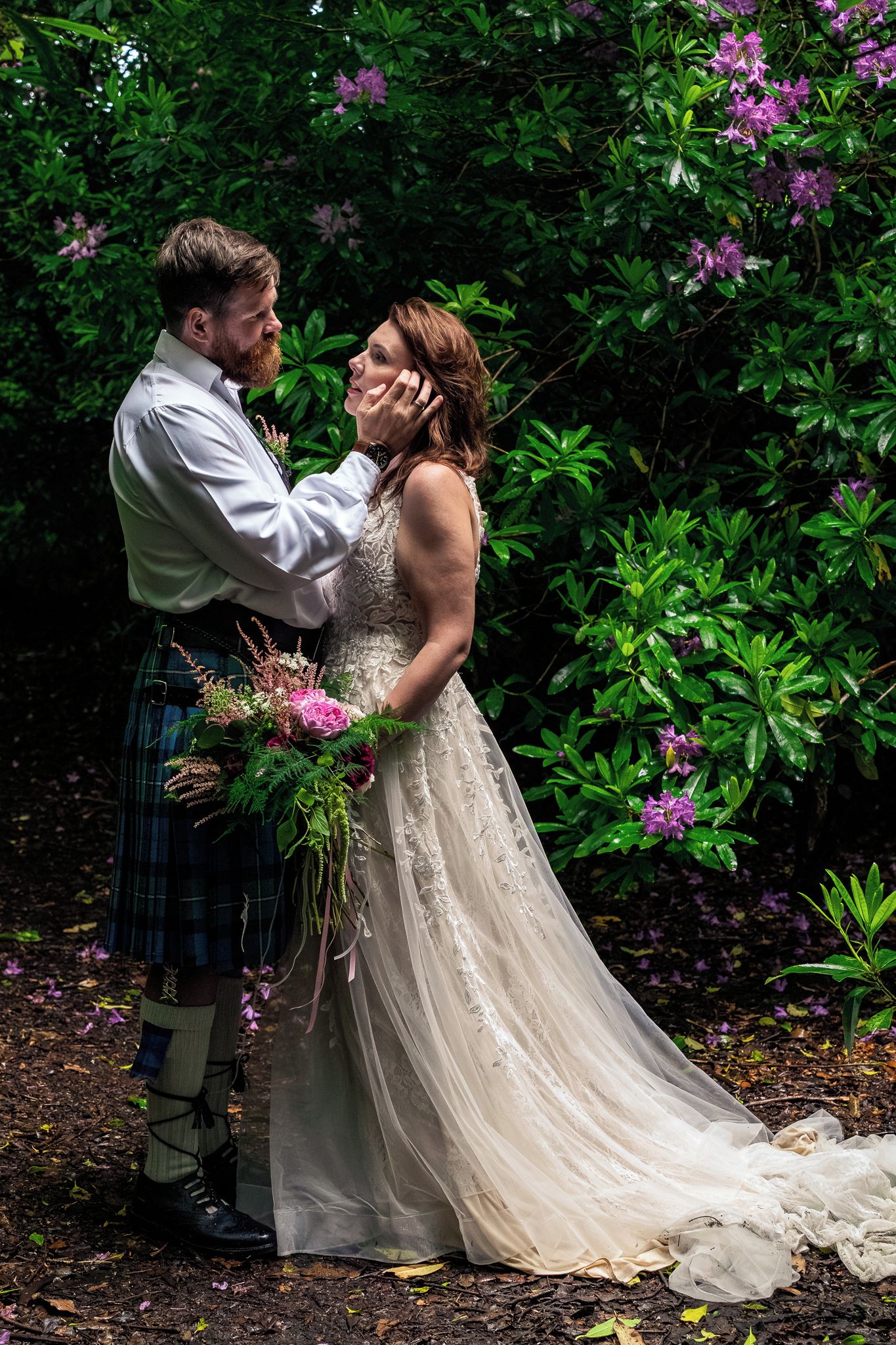 Un couple dans un jardin où la végétation est luxuriante et où les fleurs abondent.