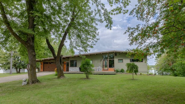 Eingeschossiges Haus mit Veranda, Garage und kleinem Rasen.