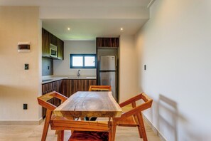 Eine moderne Küche mit Einbauofen, Kühlschrank und einem Fenster über der Spüle.