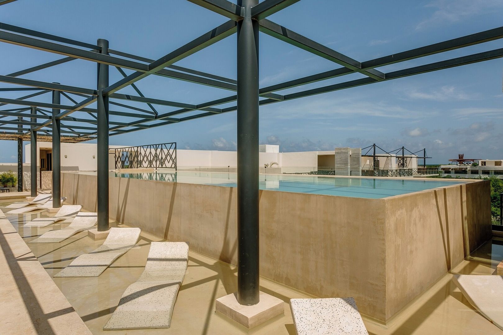 A rooftop pool area with a clear view of the surrounding buildings and a metal framework structure.
