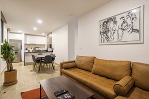 A modern living room with a sofa, a coffee table, and a dining area with chairs and a table. - Please note: electricity is not included in reservations longer than 28... (Tulum)