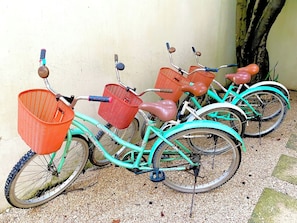 A row of bicycles with baskets, parked against a wall. - Downtown Tulum Cozy 1bd Apartment (Tulum)