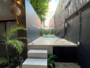 A modern outdoor space with a pool, seating, and potted plants. - Downtown Tulum Cozy 1bd Apartment (Tulum)