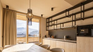 Una cocina moderna con armarios de madera, un microondas Bosch y vistas a montañas a través de amplios ventanales.