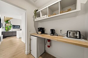 Una cuina moderna amb rentaplats integrat, cafetera, torradora i extintor.