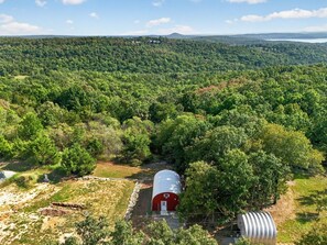 A rural landscape with a red barn and a silo.